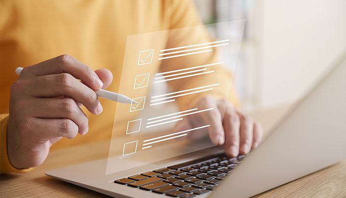 Gut formulierte Fragen sind das A und O beim Customer Effort Score. Eine Frau beantwortet an ihrem Laptop eine Befragung.
