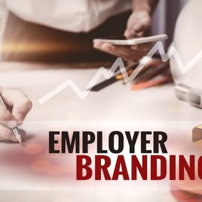 Employer Branding ist auf einen Banner geschrieben. Im Hintergrund ist ein Schreibtisch.