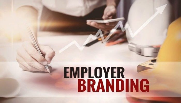 Employer Branding ist auf einen Banner geschrieben. Im Hintergrund ist ein Schreibtisch.