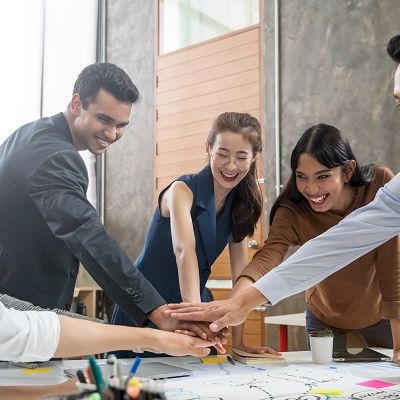 Nach einem Führungskräfte Coaching geben alle Teilnehmer ihre Hände in die Mitte.