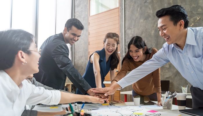 Group of Asian team creative business people join hands partnership teamwork concept