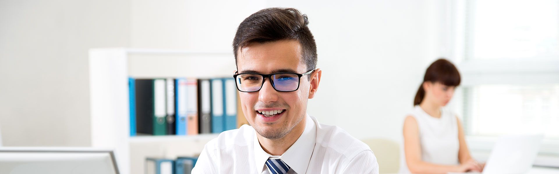 Ein Mann im Hemd sitzt vor dem PC und liest das Führungskräftefeedback durch.