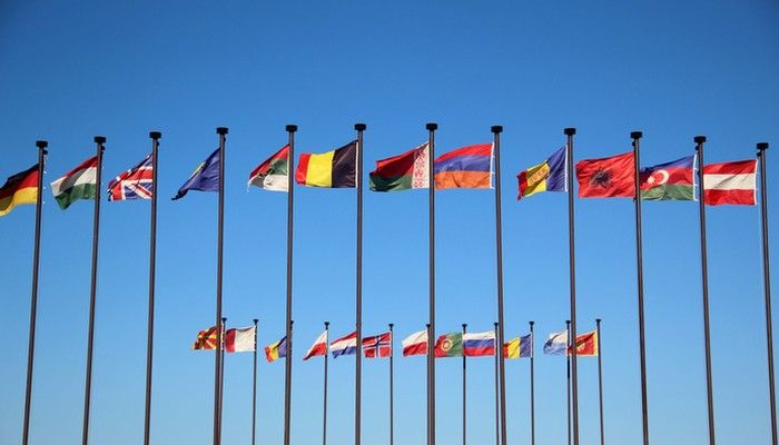 Die Vielfalt bei einer Internationale Kundenbefragung ist durch verschiedene Flaggen zu sehen, die an Masten hängen.