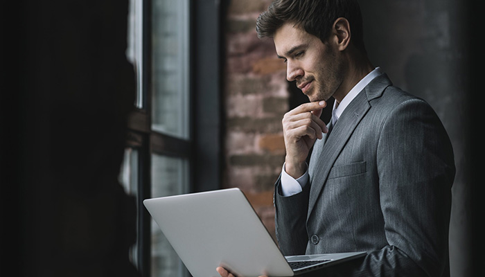 Ein Mann plant am Laptop ein Internationales Mitarbeiterfeedback.