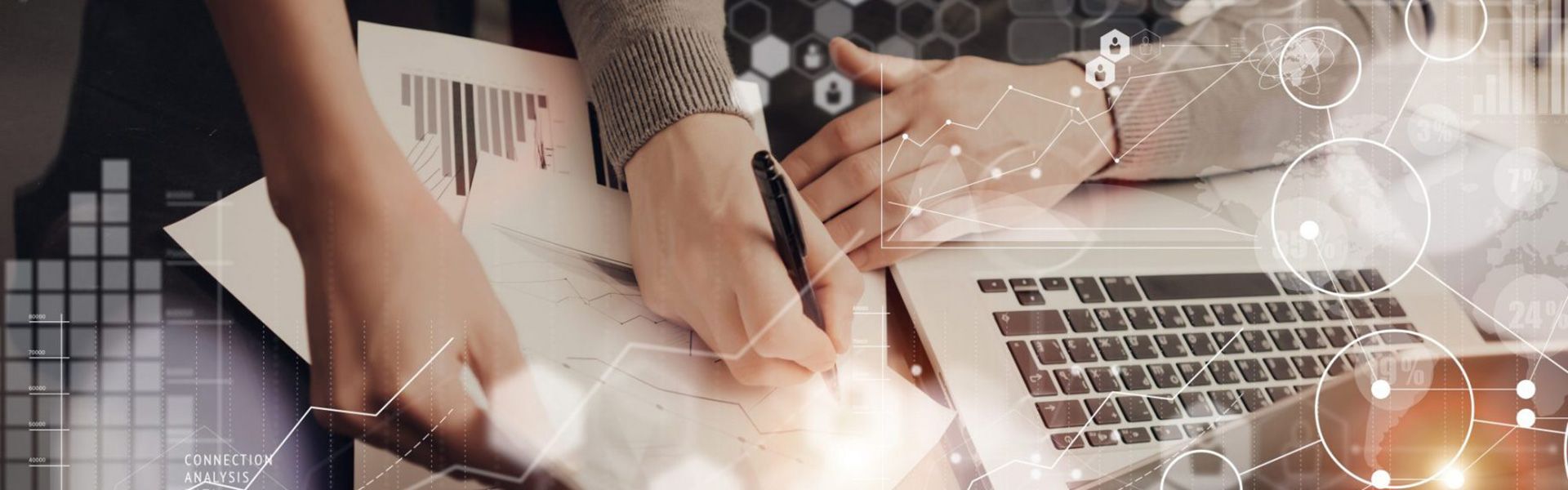 Zwei Personen planen am Schreibtisch mit Datenblättern und am Laptop einen Konzepttest.