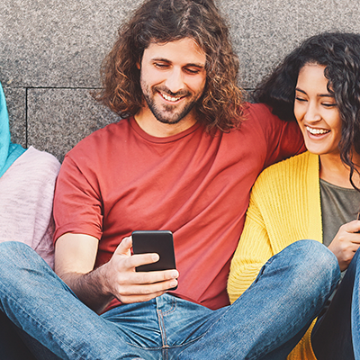 Drei junge Erwachsene führen eine Panelbefragung am Smartphone durch.