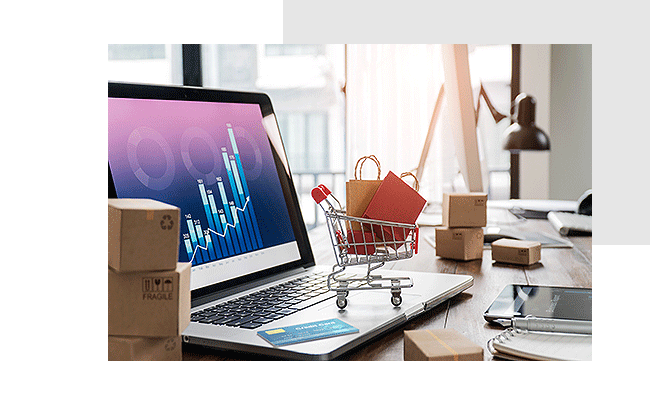 Preisforschung valide durchführen. Ein kleiner Einkaufswagen voller Taschen steht auf einem Laptop, auf dessen Bildschirm ein Preisentwicklungsdiagramm zu sehen ist.