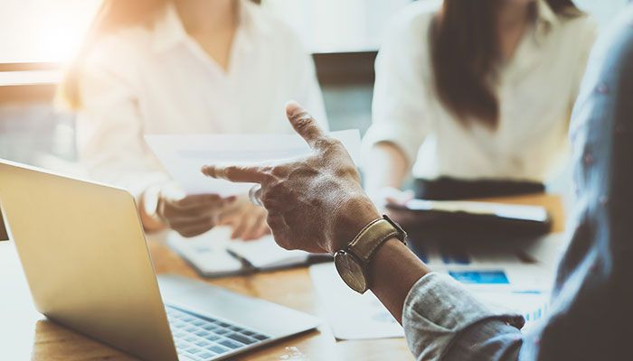 Mit einem Puls Check Feedback kontinuierlich einholen. Zwei Angestellte befinden sich im Mitarbeitergespräch mit ihrer Vorgesetzten.