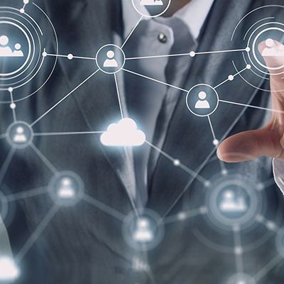 Mit Schnittstellen-Befragungen wichtige Insights gewinnen: Ein Geschäftsmann steht for einem digitalen Dashboard, auf dem ein Personen-Netz projeziert wird.