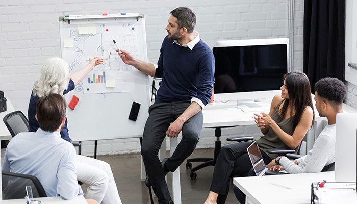 Schnittstellenanbindung muss gut überlegt sein. Ein Team überlegt an einem Whiteboard, wie sie Prozesse am besten verknüpfen.