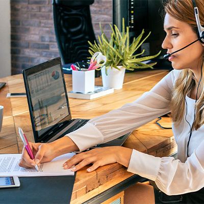 Eine Frau sitz im Büro und führt eine Touchpoint Analyse durch