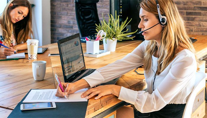 Eine Frau sitz im Büro und führt eine Touchpoint Analyse durch