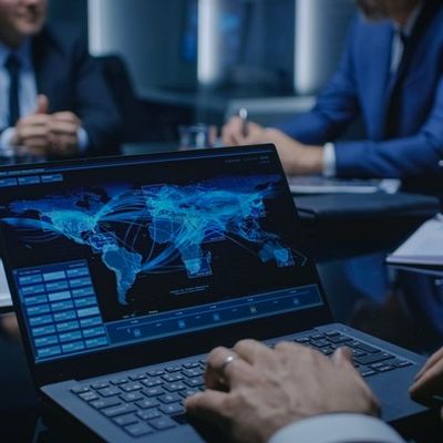 Eine Person wertet ein internationales Mitarbeiterfeedback am Computer aus.