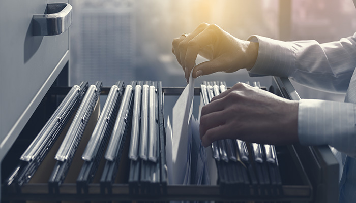 Eine Person sortiert die Akten des Mitarbeiterfeedback für Behörden.