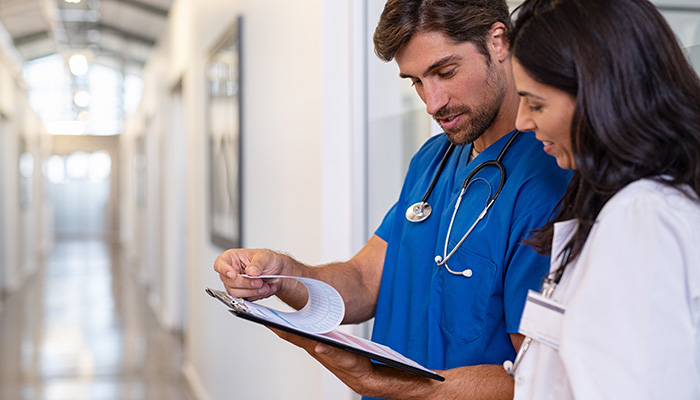 Ein Krankenpfleger gibt einer Ärztin mitarbeiterfeedback für behörden.