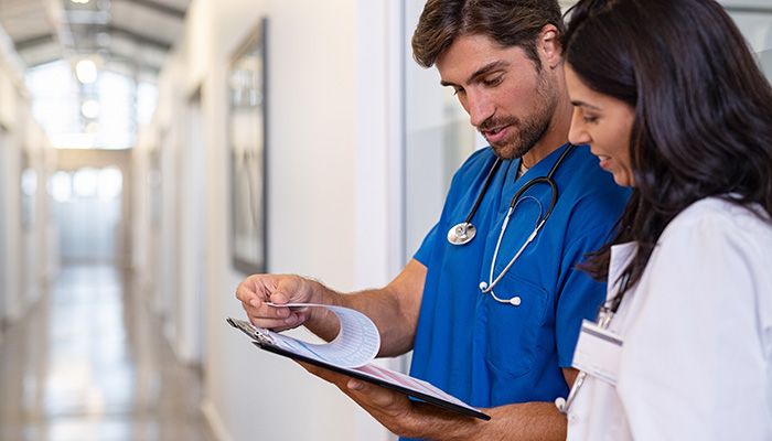 Ein Krankenpfleger gibt einer Ärztin mitarbeiterfeedback für behörden.