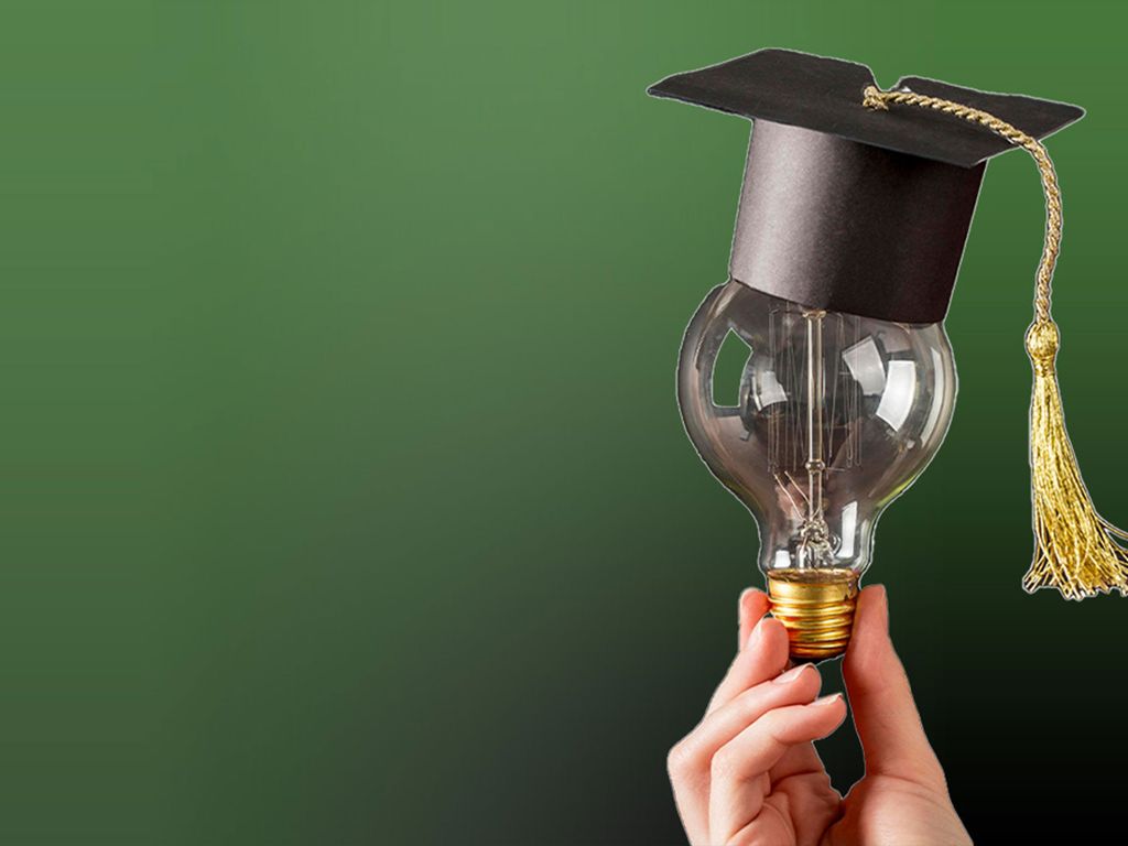 Person hält Glühbirne mit Doktorhut darauf hoch - steht für Bildungsengagment im Rahmen sozialer Nachhaltigkeit