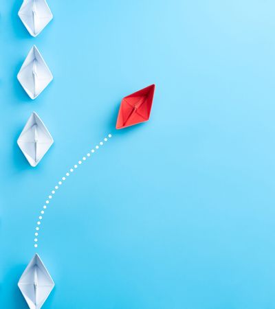 Change Management Rotes Papierboot tanzt aus der Reihe