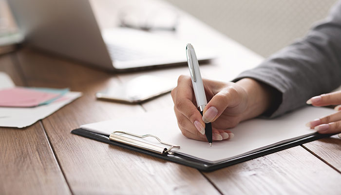 Eine Frau füllt einen Fragebogen zum Betriebsklima aus.