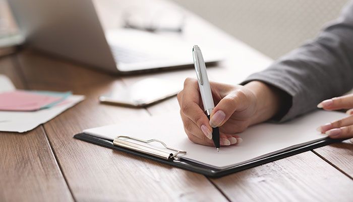 Eine Frau füllt einen Fragebogen zum Betriebsklima aus.