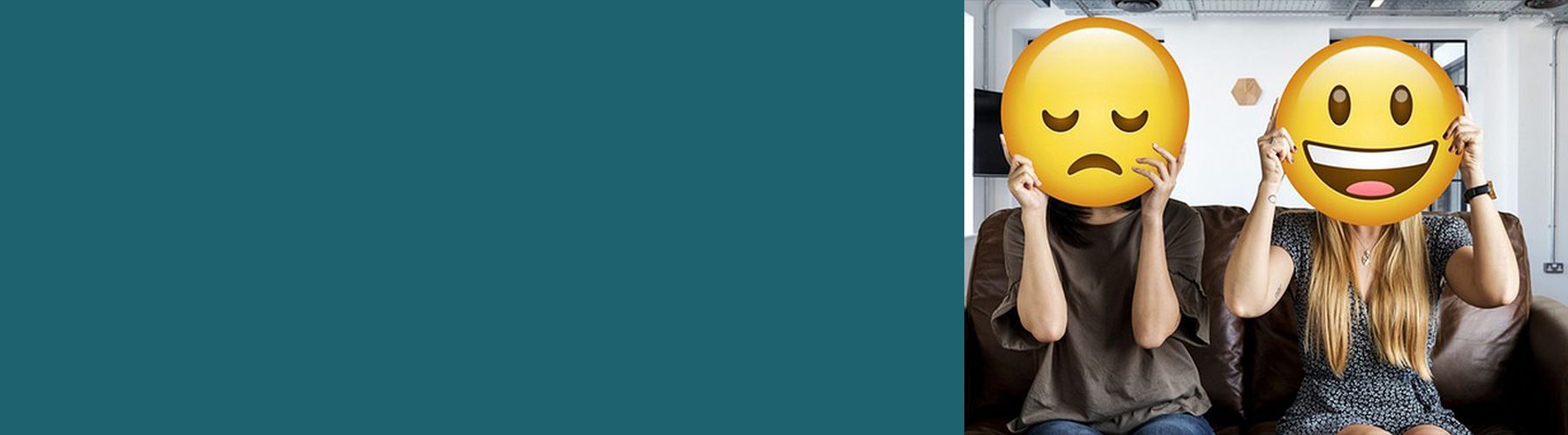 2 Mitarbeiterinnen im Büro halten sich Smileys vors Gesicht: Gutes Betriebsklima und schlechtes Betriebsklima.