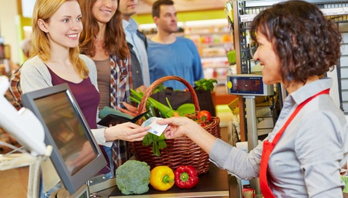 Freundlichkeit, wie hier an der Kasse, erhöht der CSAT.