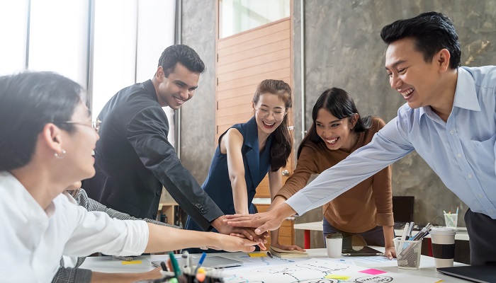 Nach einem Change Management geben alle Teilnehmer ihre Hände in die Mitte.