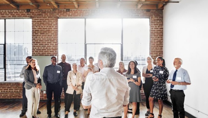 Ein Mann steht vor einem Team und spricht über das Thema Change Management.