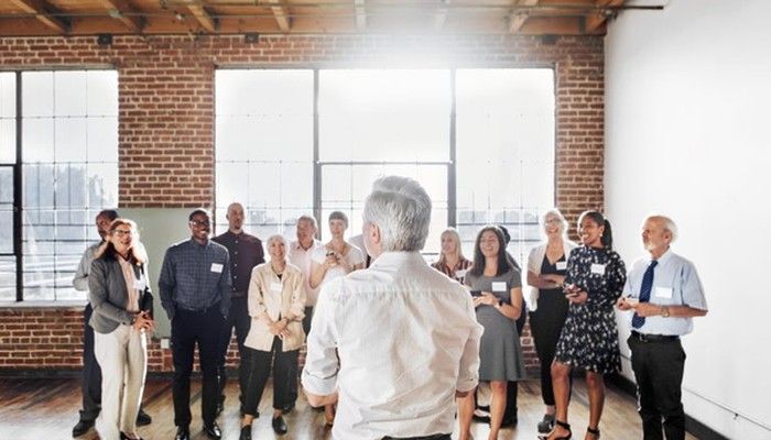 Ein Mann steht vor einem Team und spricht über das Thema Change Management.