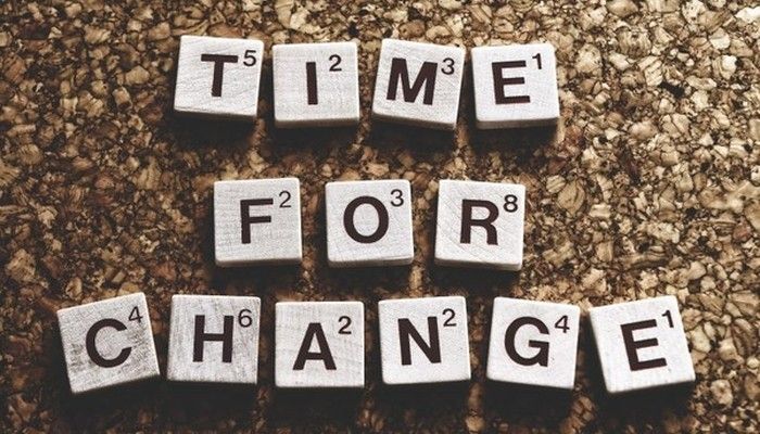 Ein paar Steine mit Buchstaben liegen nebeneinander und ergeben das Wort time for Change Management.