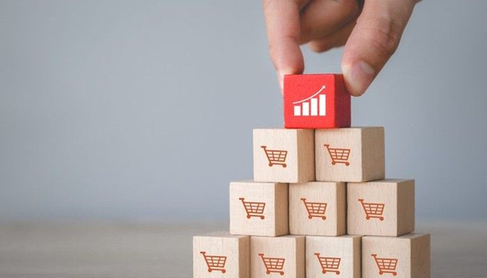 Eine Person stapelt Holzblöcke mit Einkaufskörben übereinander und symbolisiert eine Customer Lifetime Value.