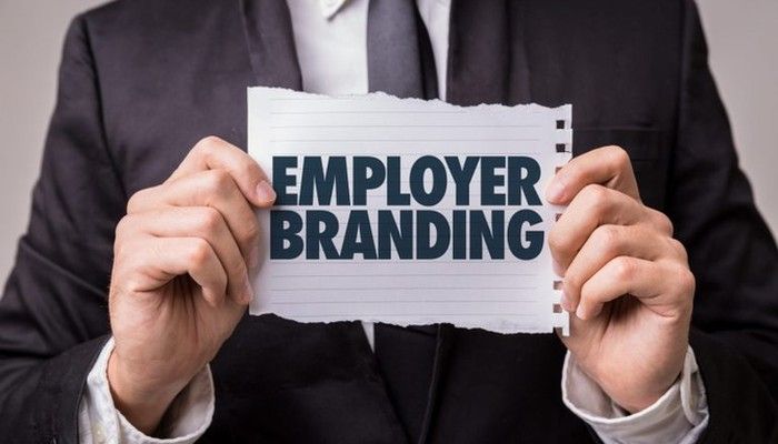 Eine Person hält ein Schild mit den Worten Employer Branding hoch.