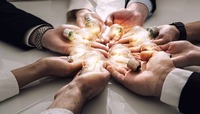 Nach dem Employer Branding halten mehrere Personen Glühbirnen in den Händen.