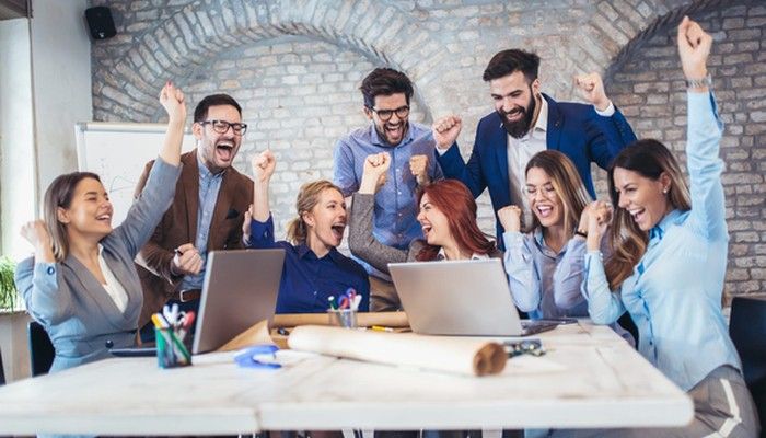 Eine Gruppe freut sich im Büro über die Employer Value Proposition.