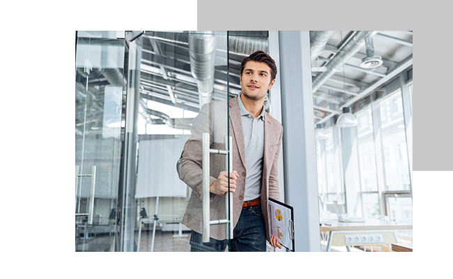 Ein Mann hält die Ergebnisse eines Exit-Interviews in der Hand und betritt ein Bürozimmer.