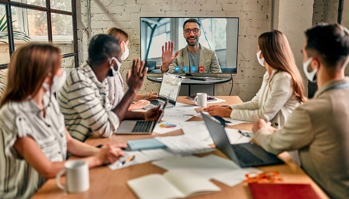 Ein Mann zeigt Führungskompetenz während der Pandemie und leitet sein Team über einen Videocall.