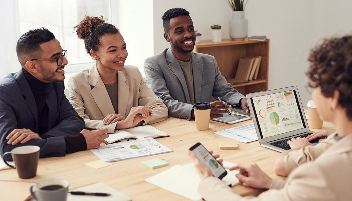Eine Team diskutiert am Tisch zum Thema Führungskompetenz.