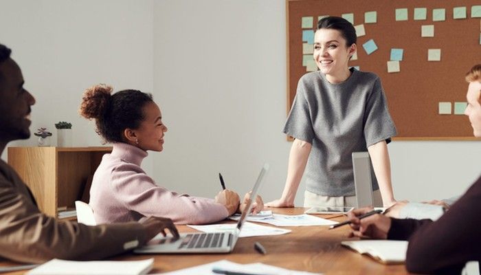 Eine Frau erklärt ihrem Team den Plan zum Führungskräfte Coaching.