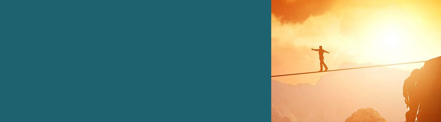Eine Person balanciert auf einem Seil zwischen zwei Bergen und symbolisiert damit wie man eine Gefährdungsbeurteilung durchführen kann.
