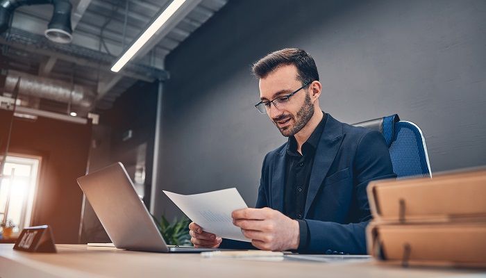 Ein Mann sitzt im Büro und bearbeitet eine hybride Befragung.