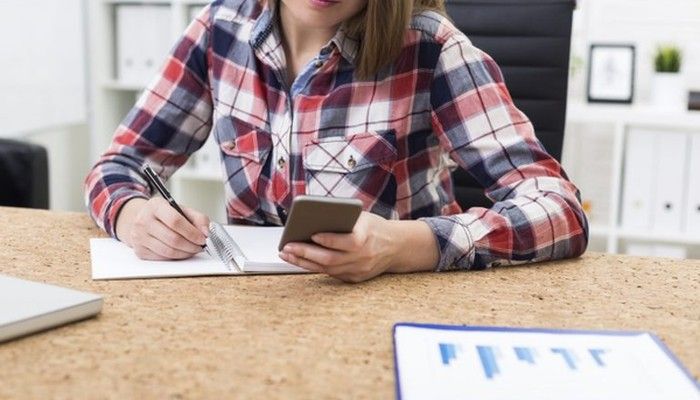 Eine Frau sitzt am Tisch und führt eine Hybride Befragung durch.
