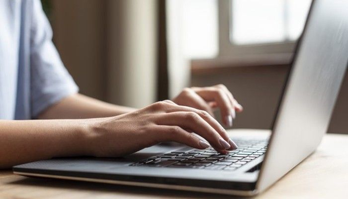 Eine Frau füllt eine Internationale Kundenbefragung am Laptop aus.