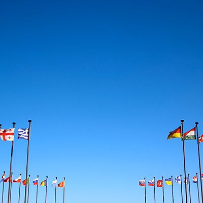 Internationales Mitarbeiterfeedback wird durch verschiedene Länderflaggen dargestellt.