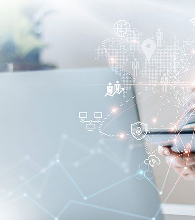 Eine Person steht mit einem Tablet vor dem Laptop und unternimmt eine Korrelationsanalyse.