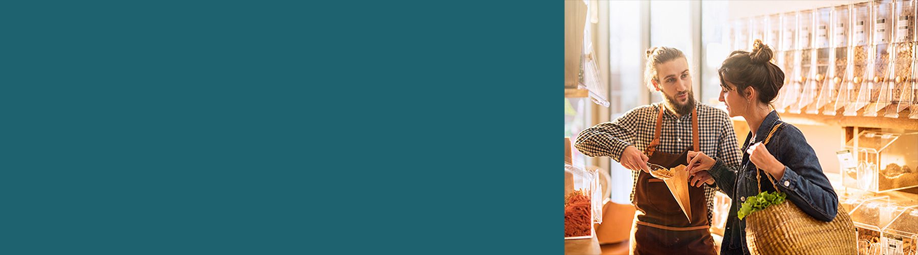 Ein Mitarbeiter hilft einer Kundin im Laden Nüsse in eine Tüte zu packen und stärkt dadurch die Kundenbindung.