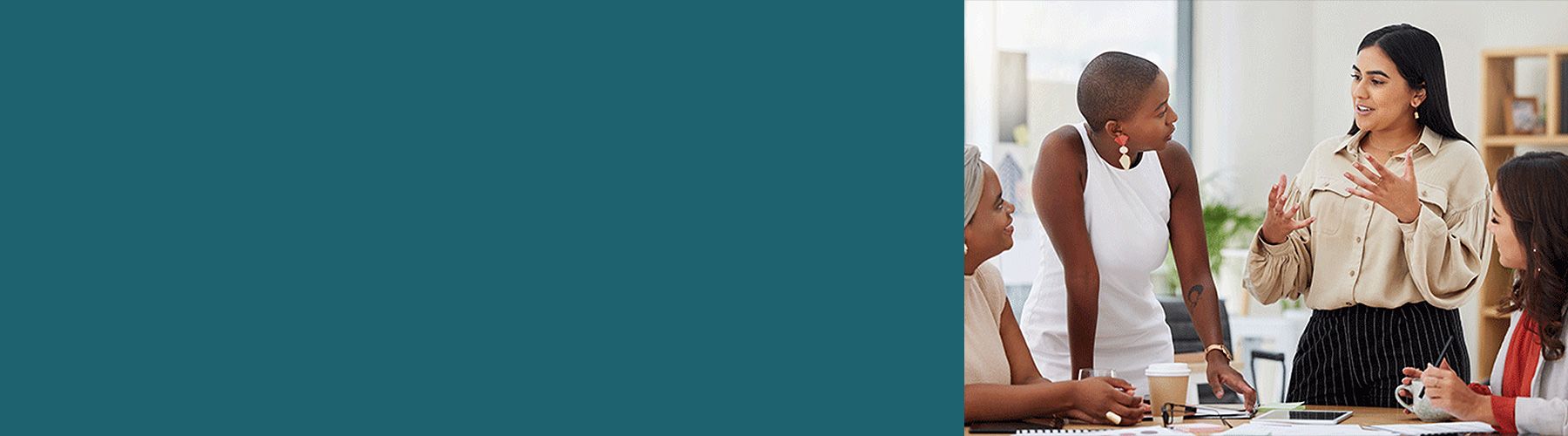 Vier Frauen stehen an einen Tisch und reden über die Kundenzufriedenheit.