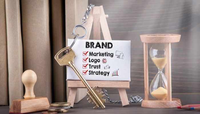Um eine Marktforschung zu symbolisieren ist auf einer Miniatur Staffelei ein Bild mit dem Wort Brand aufgestellt, unter dem weiter Begriffe abgehakt sind. Nebendran ist ein Schlüssel, eine Sanduhr, ein Stempel und Geld zu sehen.