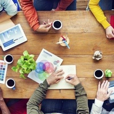 Ein Team berät sich am Tisch über eine Mitarbeiterbefragung Öffentlichen Dienst