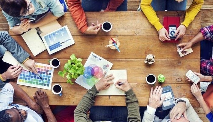 Ein Team berät sich am Tisch über eine Mitarbeiterbefragung Öffentlichen Dienst