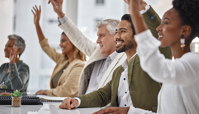 Viele Teilnehmenden einer Unternehmensbesprechung haben etwas beizutragen. Dies stellt gute Mitarbeiterbindung durch offene Kommunikation dar.